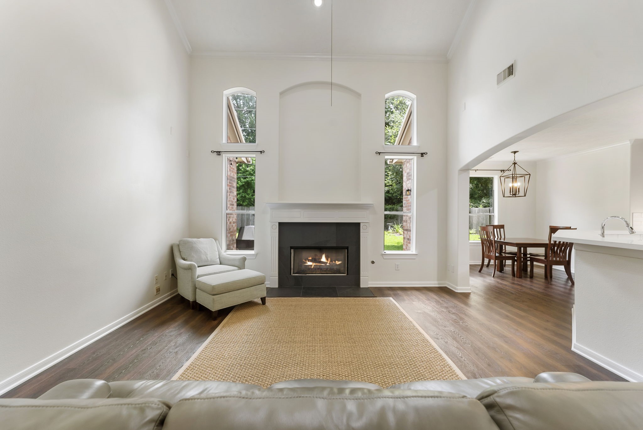 6643 Knollbridge Lane Spring, TX 77379 - Photo 14 of 50 Warming fireplace flanked by expansive windows with views of the mature trees from the greenbelt tucked behind you.