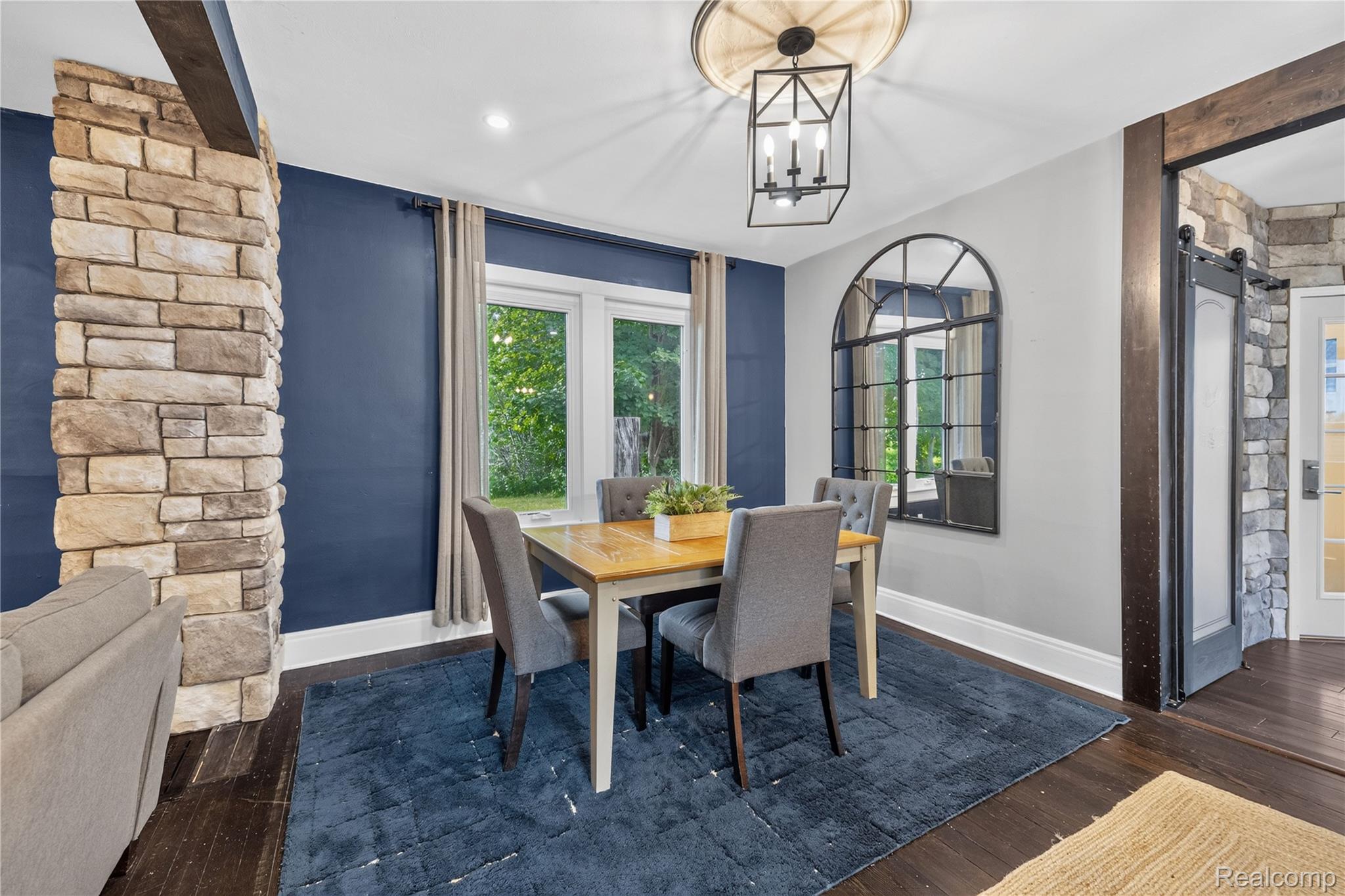 4860 Blue Bush Road Monroe, MI 48162 - Photo 16 of 59 Dining area featuring dark wood-finish flooring, a stone-clad architectural detail, and a decorative light fixture