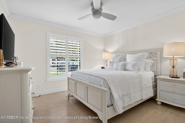a bedroom with a bed a mirror on dresser and a window