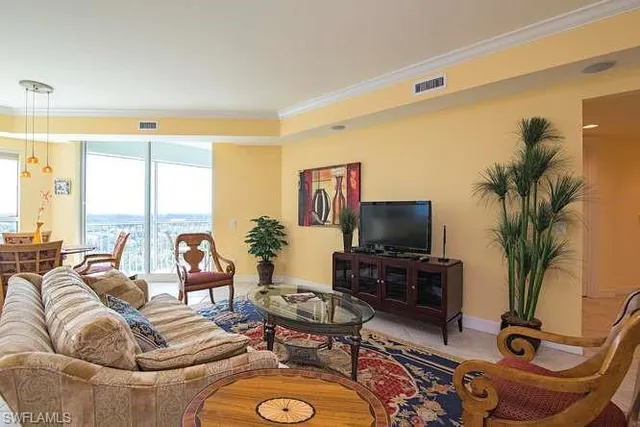 a living room with furniture flat screen tv and a large window
