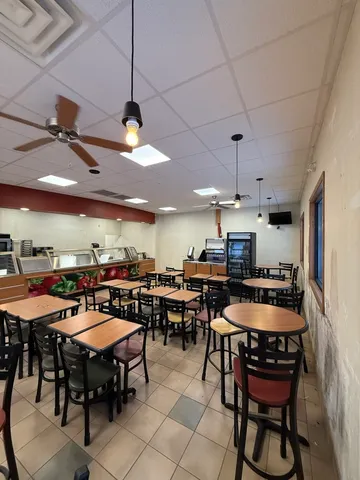 a dining room with stainless steel appliances kitchen island a table and chairs