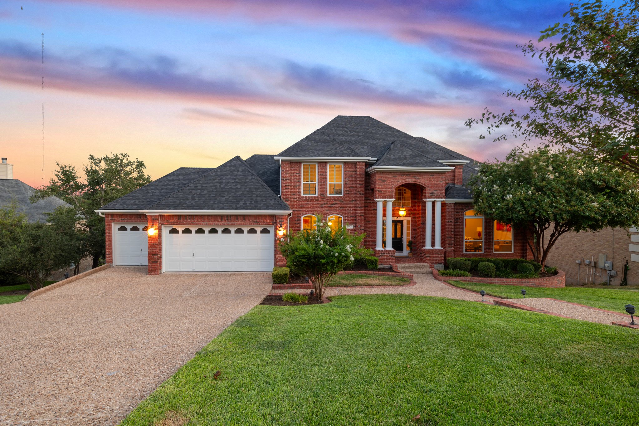 2807 Round Table Road Austin, TX 78746 - Photo 36 of 40 View of front of home featuring brick siding,and an attached 3 car garage. A blend of traditional and modern inside.
