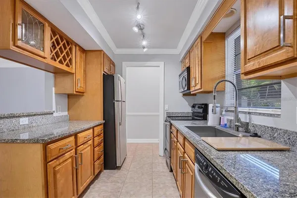 a kitchen with stainless steel appliances granite countertop a sink a stove and a refrigerator