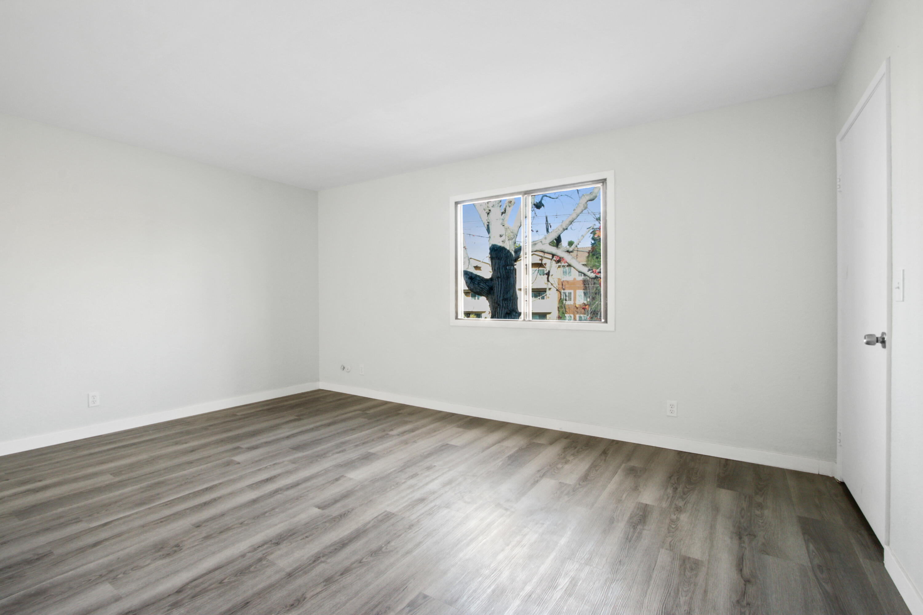 9542 Ball Road, Unit 1 Anaheim, CA 92804 - Photo 15 of 24 an empty room with wooden floor and windows