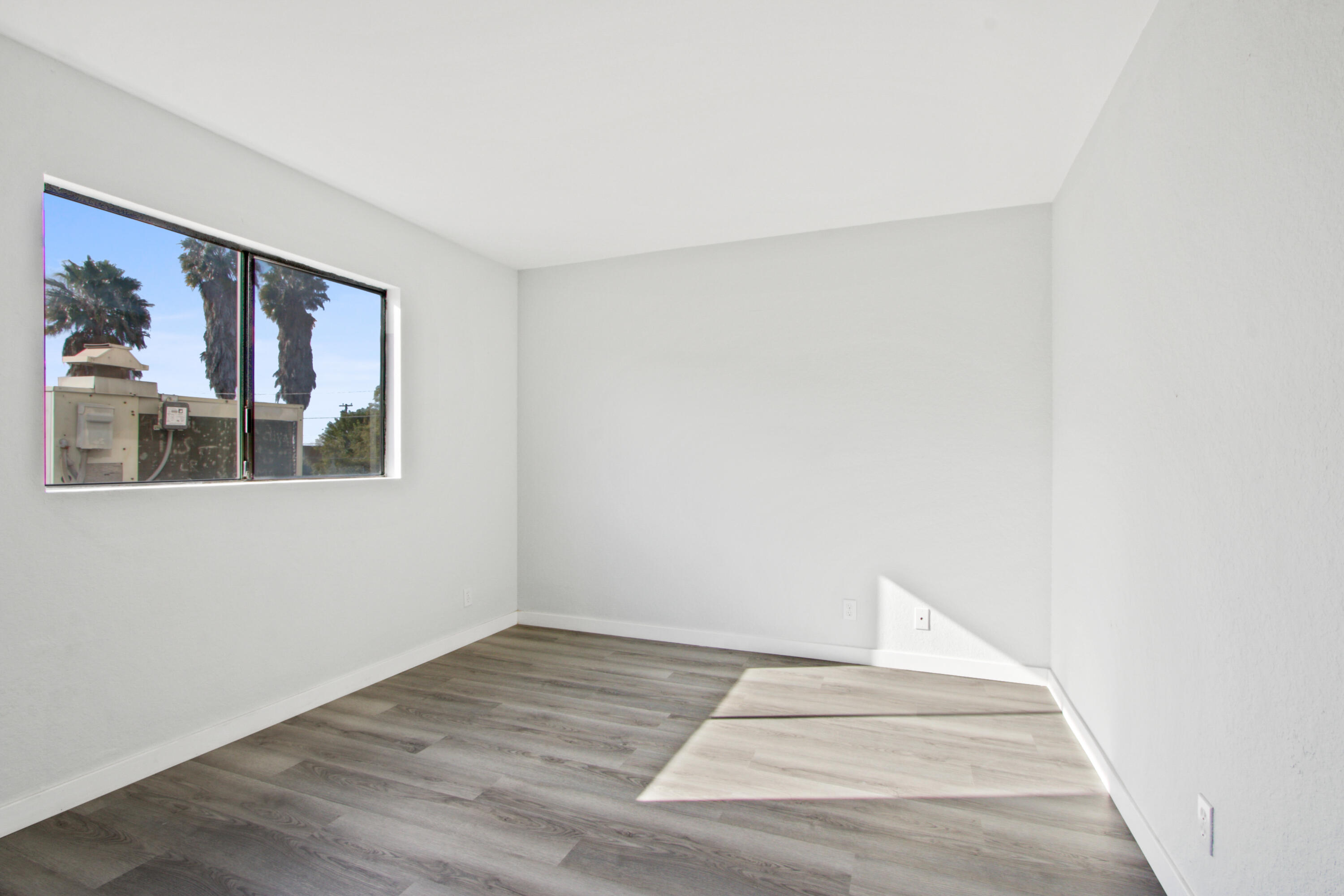 9542 Ball Road, Unit 1 Anaheim, CA 92804 - Photo 19 of 24 a view of an empty room with wooden floor and a window