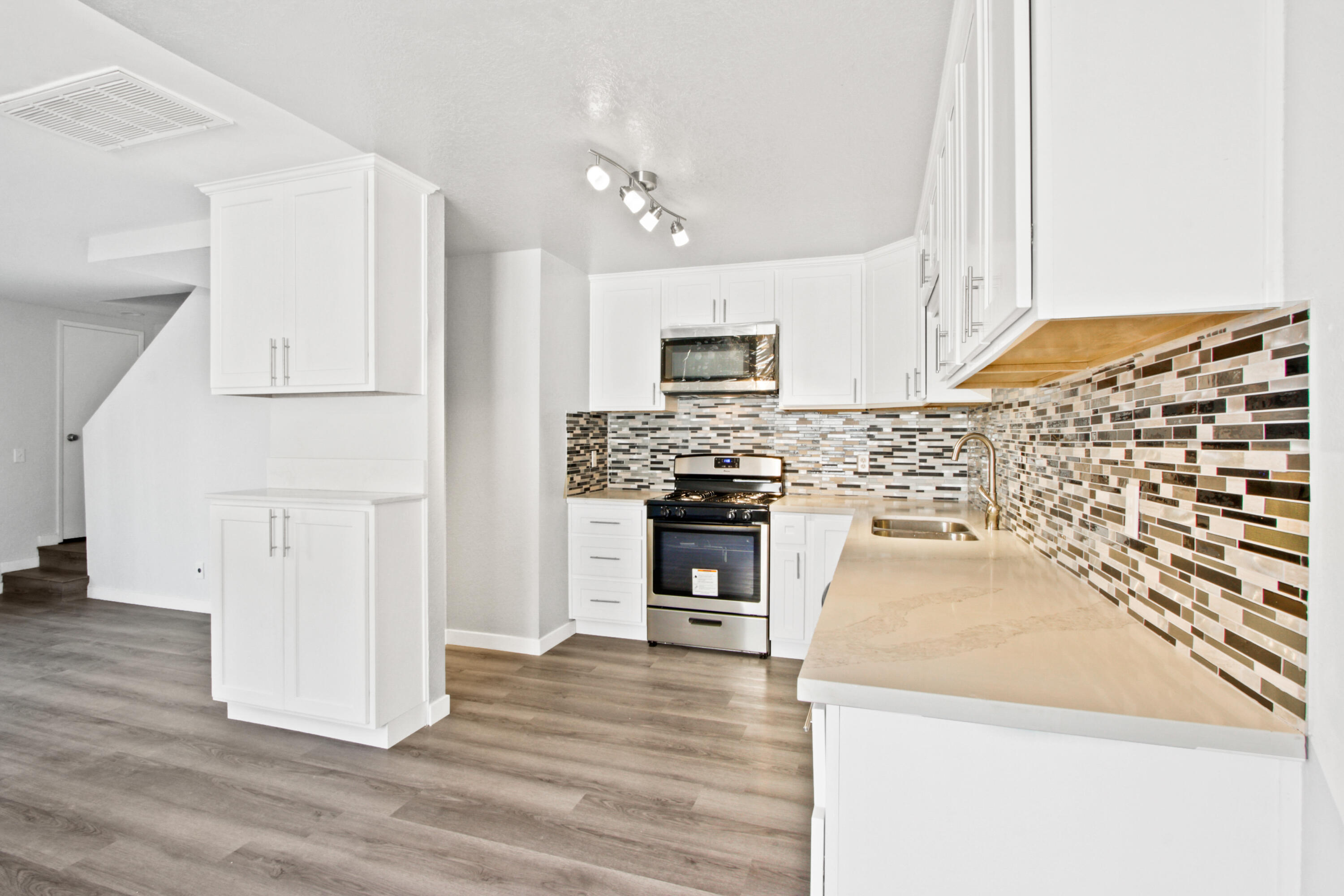9542 Ball Road, Unit 1 Anaheim, CA 92804 - Photo 2 of 24 a kitchen with granite countertop a refrigerator and a stove top oven