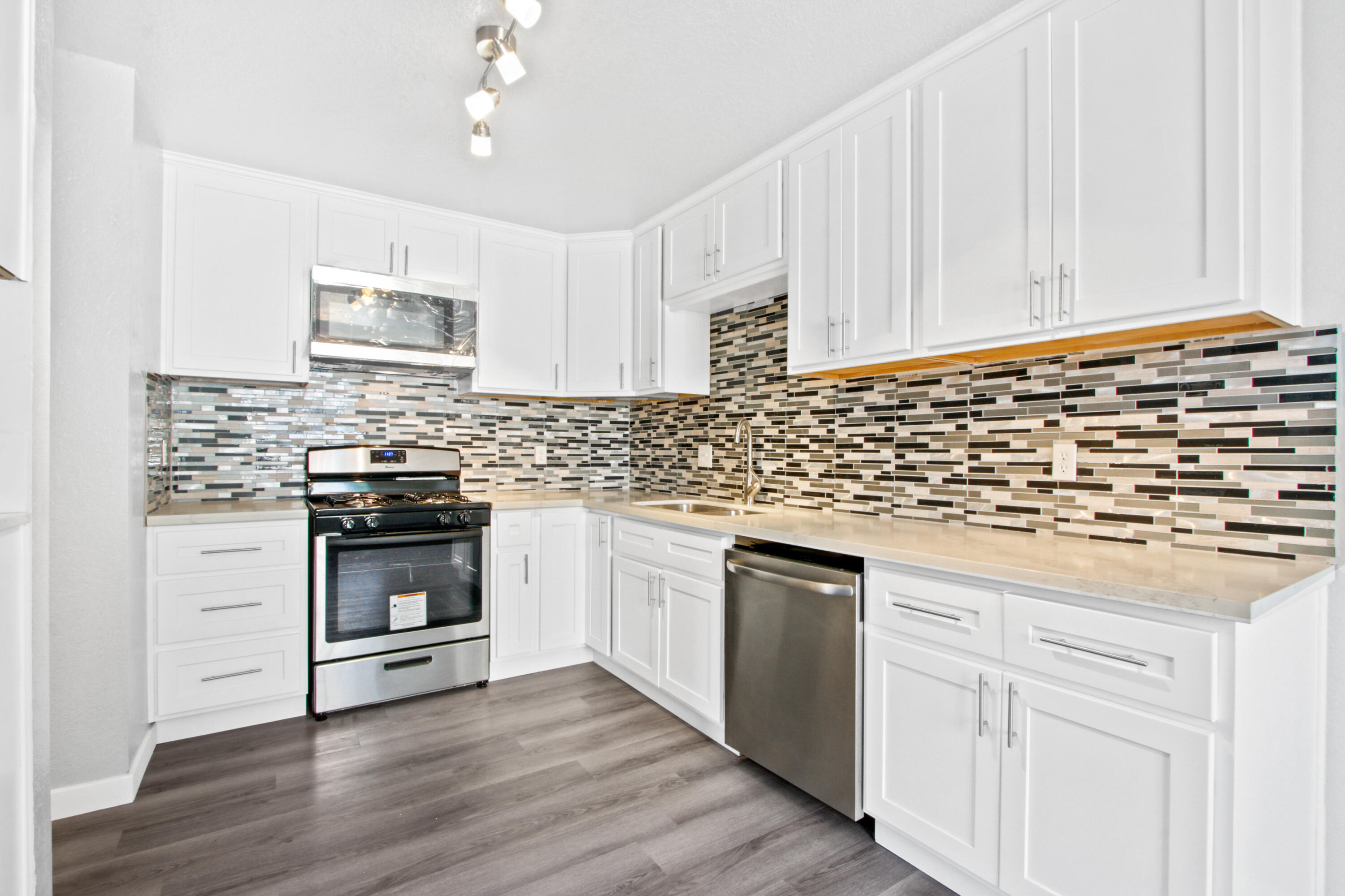 9542 Ball Road, Unit 1 Anaheim, CA 92804 - Photo 4 of 24 a kitchen with granite countertop white cabinets and white appliances