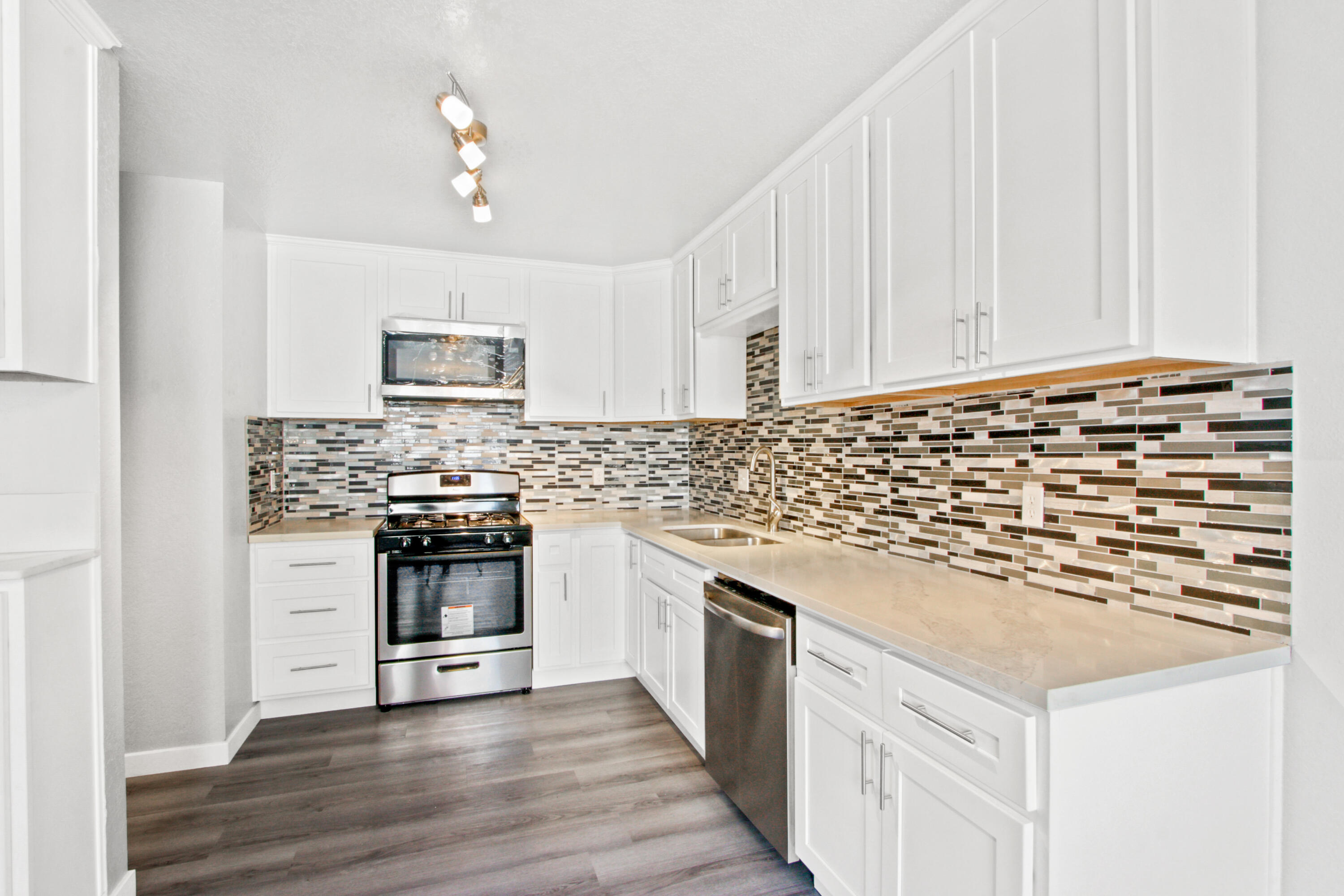 9542 Ball Road, Unit 1 Anaheim, CA 92804 - Photo 6 of 24 a kitchen with granite countertop white cabinets and stainless steel appliances