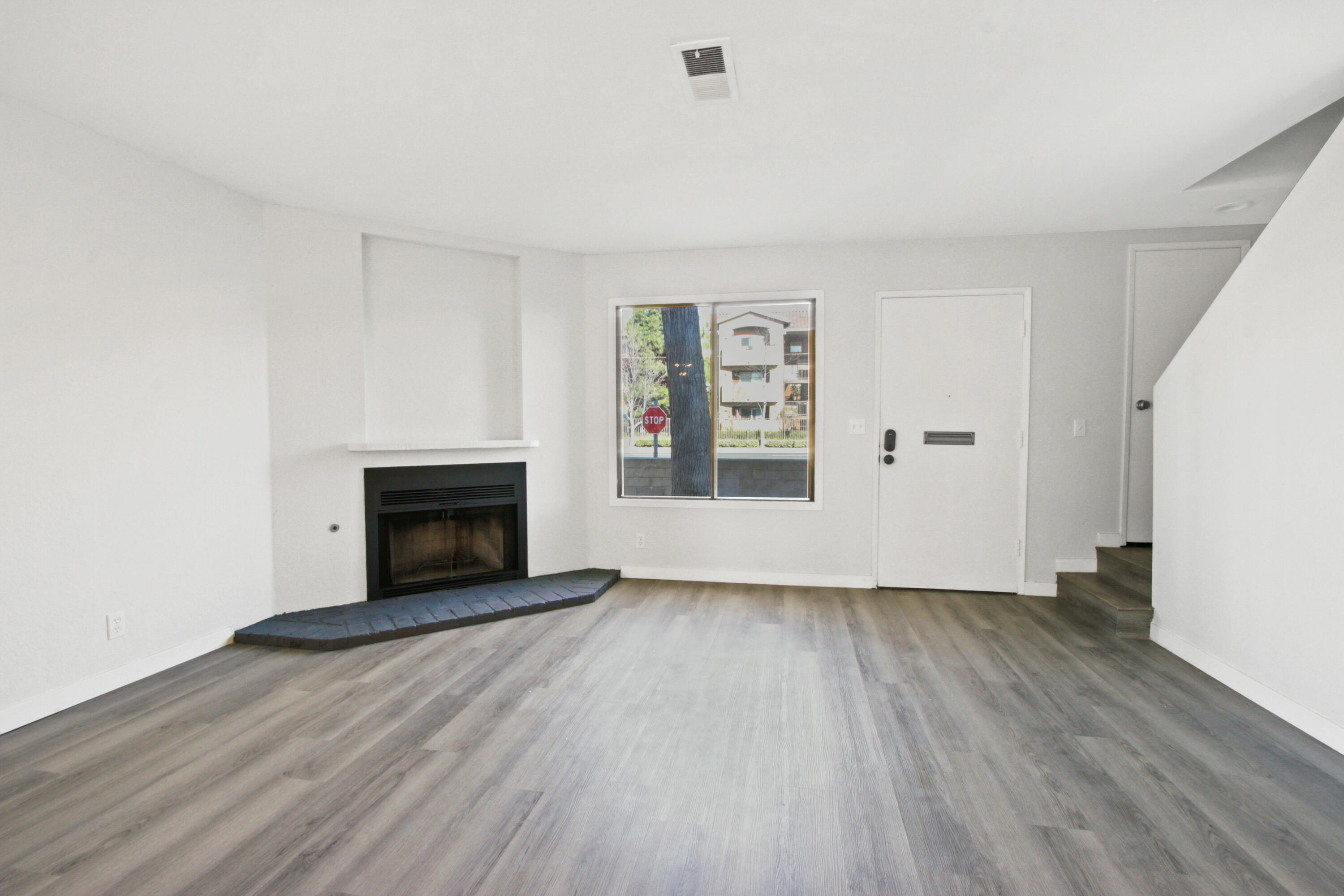 9542 Ball Road, Unit 1 Anaheim, CA 92804 - Photo 9 of 24 an empty room with wooden floor fireplace and windows