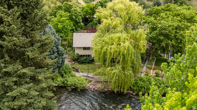 1365 Sumac Drive Logan, UT 84321 - Photo 74 of 84 Two-story residence with a light-toned exterior and a gabled roof, nestled among abundant mature trees