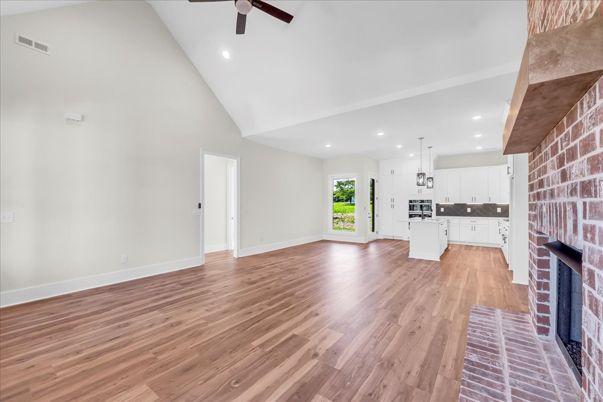 309 Hickory Grove Drive Morrison, TN 37357 - Photo 14 of 50 a view of empty room with wooden floor and kitchen view