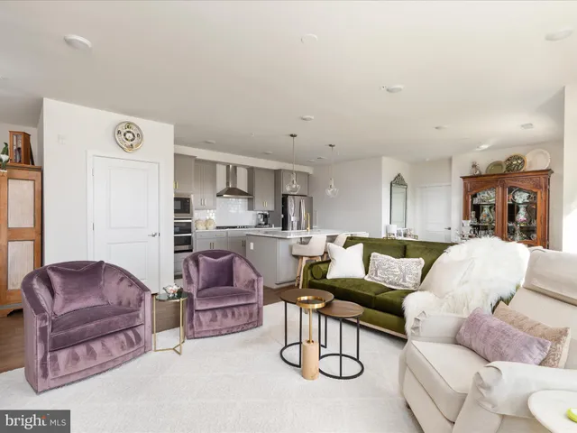 a living room with furniture kitchen view and a refrigerator
