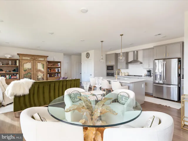 a kitchen with stainless steel appliances granite countertop a kitchen island a stove a table and chairs