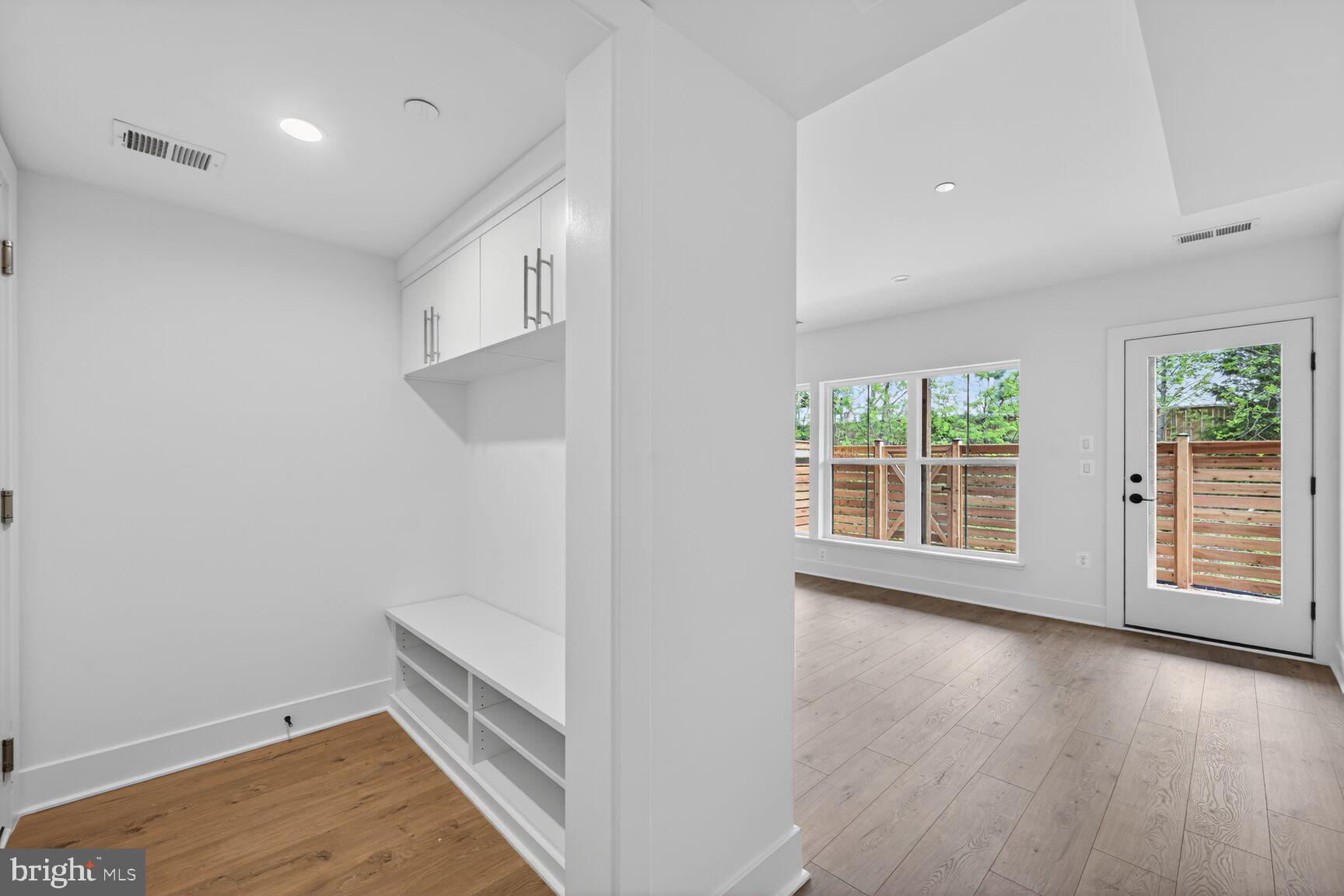 1135 Polaris Road, Unit NOTTINGHAM 101 Potomac, MD 20854 - Photo 11 of 26 an empty room with wooden floor and windows