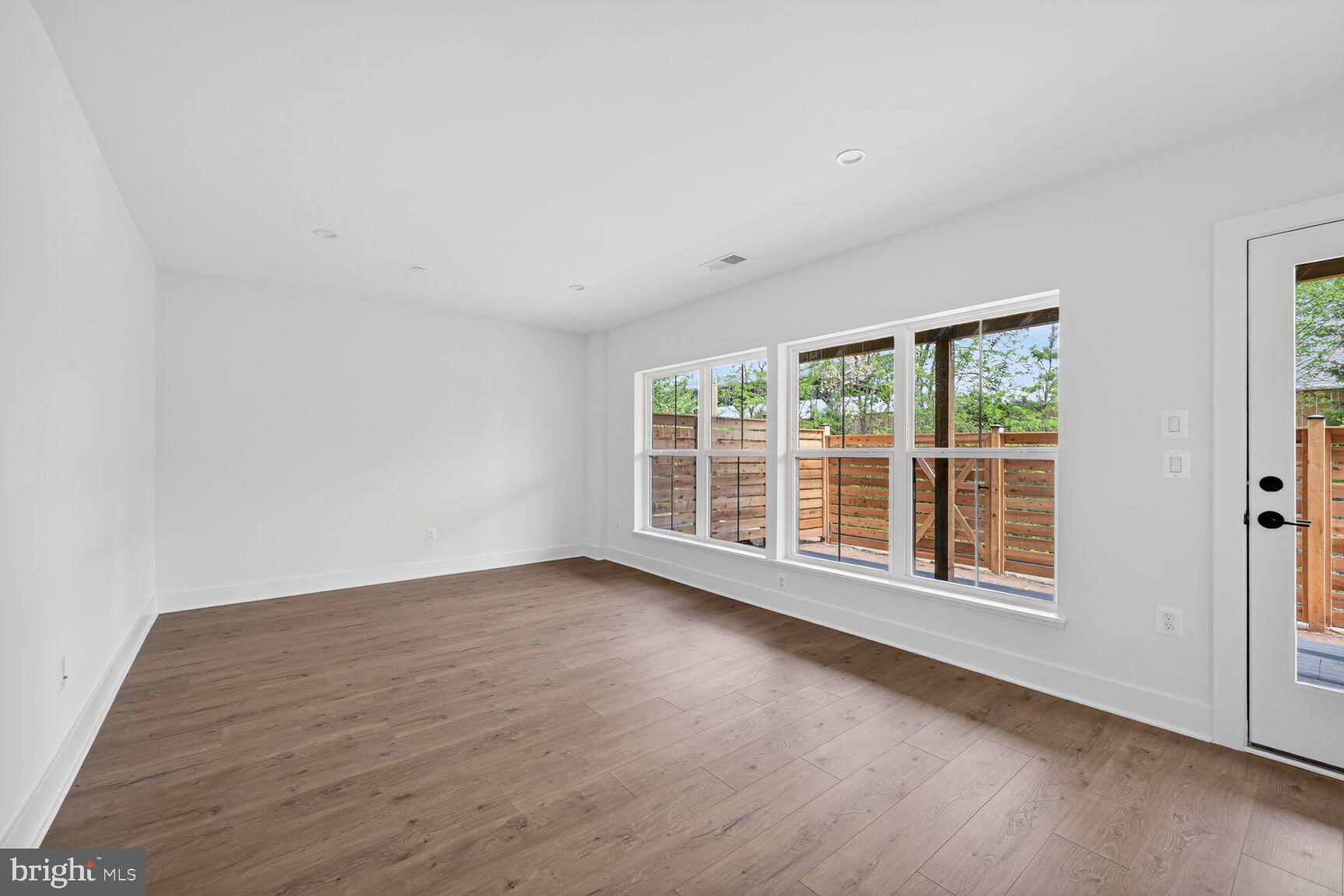 1135 Polaris Road, Unit NOTTINGHAM 101 Potomac, MD 20854 - Photo 12 of 26 a view of an empty room with wooden floor and a window