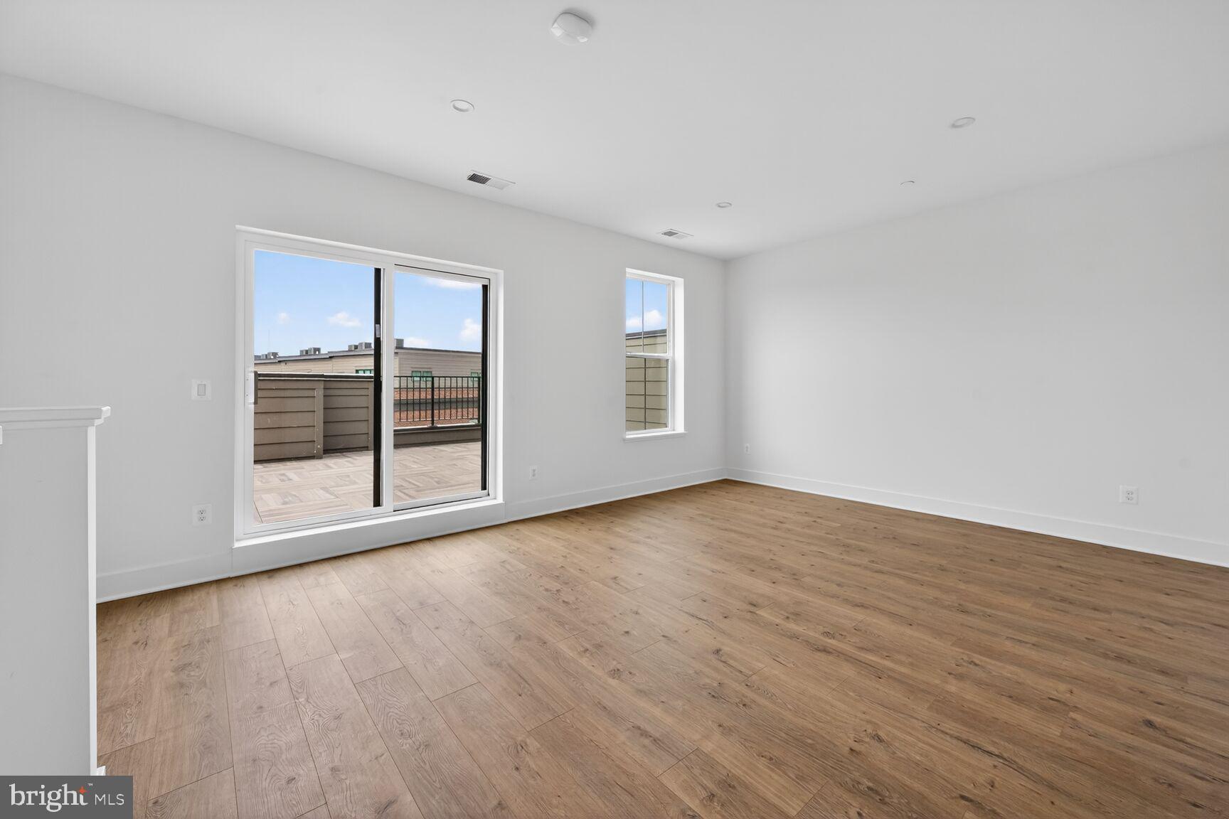 1135 Polaris Road, Unit NOTTINGHAM 101 Potomac, MD 20854 - Photo 21 of 26 a view of an empty room with wooden floor and a window