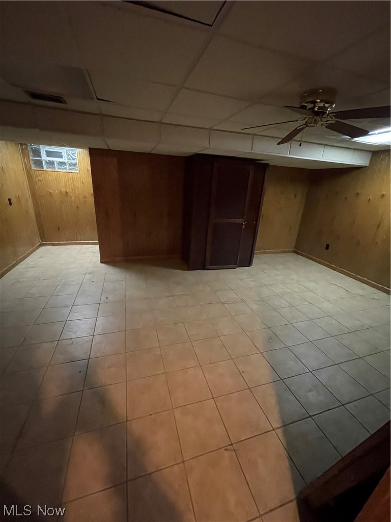 4018 Dover Road Youngstown, OH 44511 - Photo 20 of 31 Basement with wooden walls, ceiling fan, light tile flooring, and a paneled ceiling