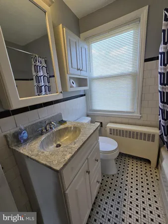 a bathroom with a granite countertop sink toilet a mirror and a shower