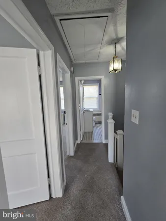 a view of a hallway with a livingroom and stairs