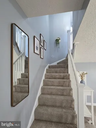 a view of staircase with lots of frames on wall and a window