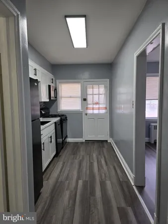 a kitchen with a sink wooden floor and stainless steel appliances