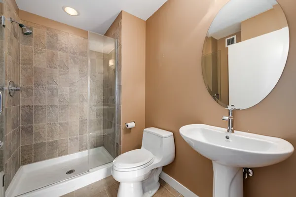 a bathroom with a sink a toilet and shower