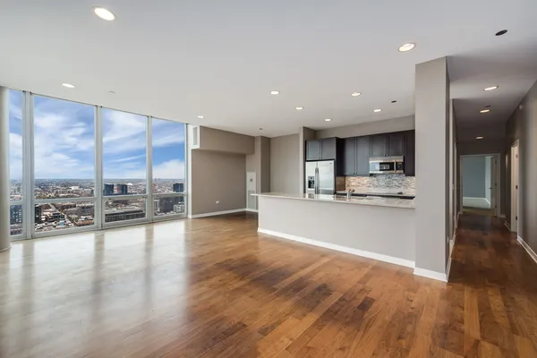 a view of a kitchen with kitchen island a counter top space a sink and cabinets