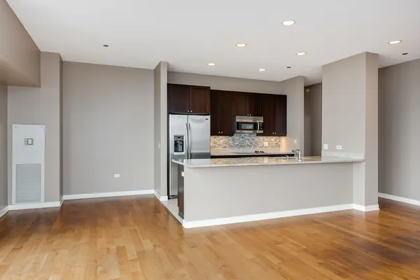 a view of kitchen with stainless steel appliances granite countertop a refrigerator and a sink