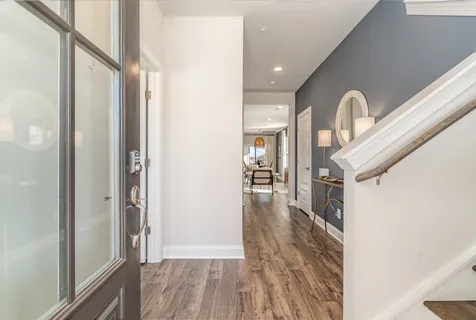 a view of a hallway with wooden floor and a chandelier