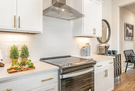a white stove top oven sitting inside of a kitchen