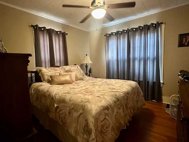a bed sitting in a spacious bedroom next to a window and a chandelier