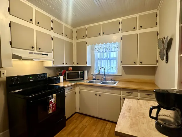 a kitchen with a sink a stove and cabinets