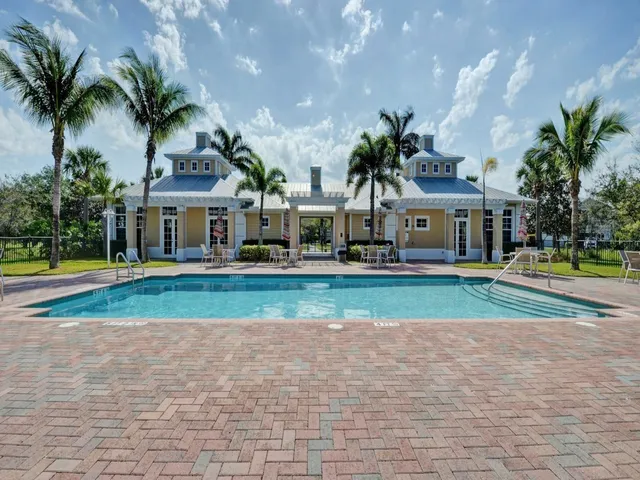 a front view of a house with a yard and palm trees