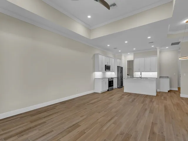 a view of a kitchen with wooden floor and large windows