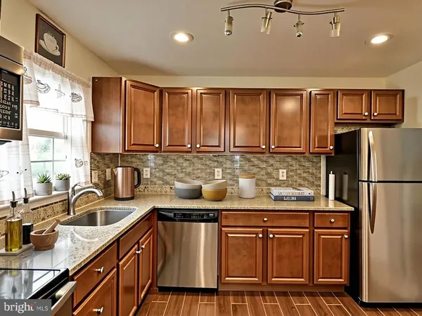 a kitchen with stainless steel appliances granite countertop a sink stove and refrigerator