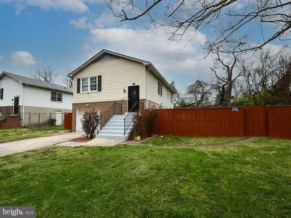 a view of a house with a yard and fence