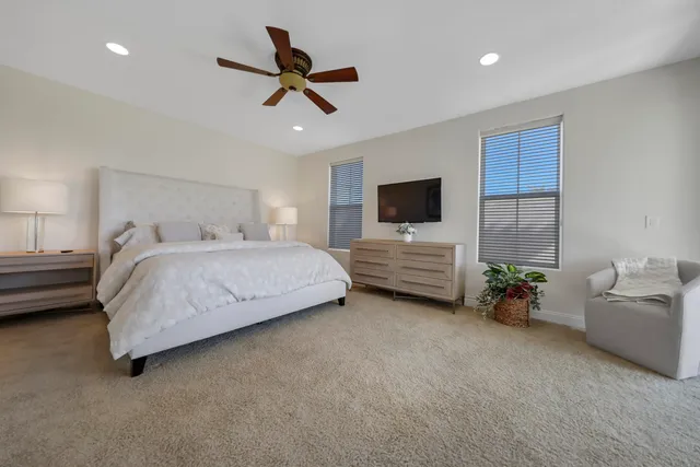 a bedroom with a bed a couch and a chandelier