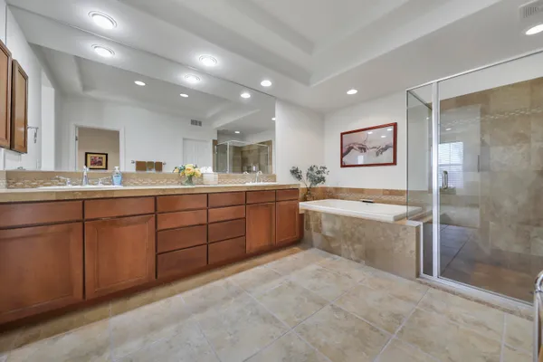 a large bathroom with a double vanity sink a large mirror and a bathtub