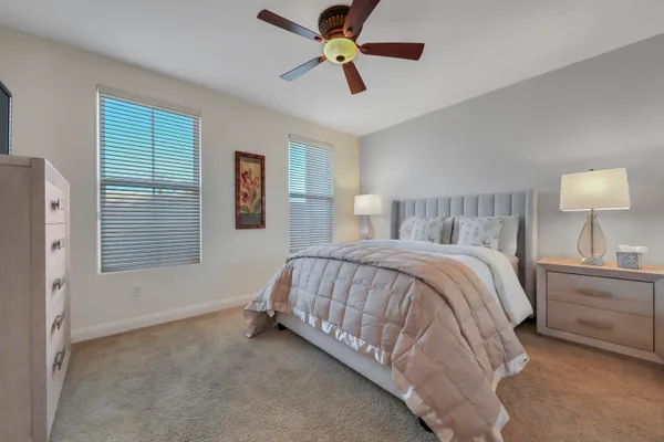 a spacious bedroom with a bed and a chandelier