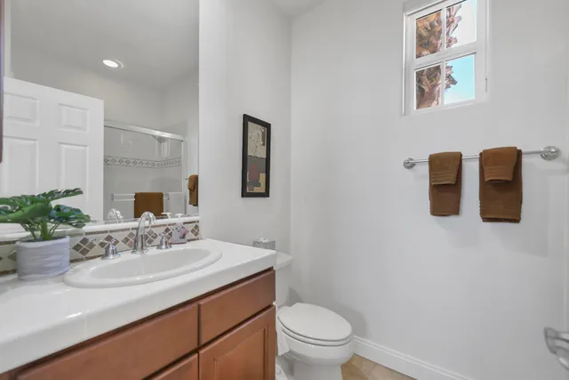 a bathroom with a sink vanity granite and toilet