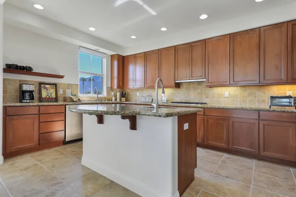 a kitchen with stainless steel appliances granite countertop a stove sink and cabinets