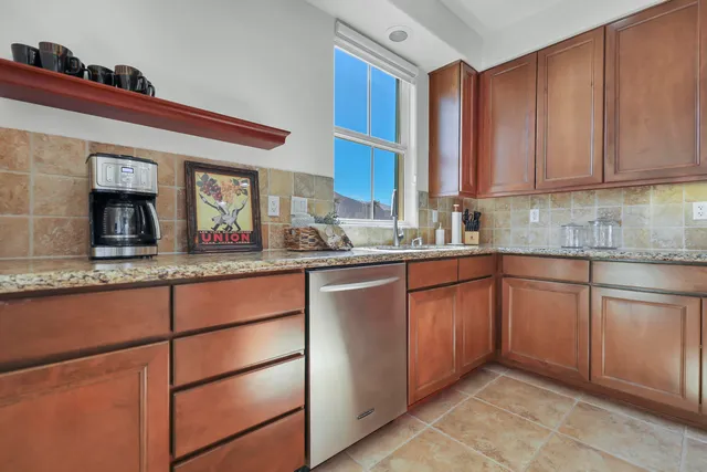 a kitchen with stainless steel appliances granite countertop a sink and cabinets