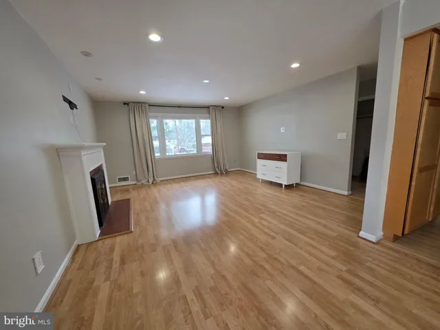 a view of empty room with window and wooden floor