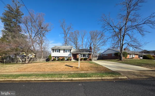a front view of a house with a yard covered in snow