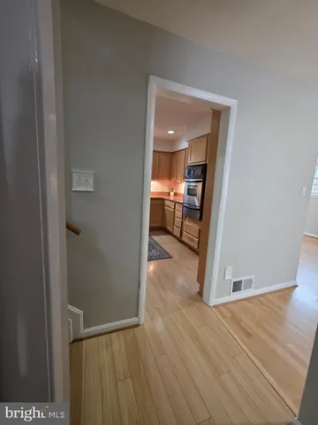 an empty room with wooden floor and a ceiling fan