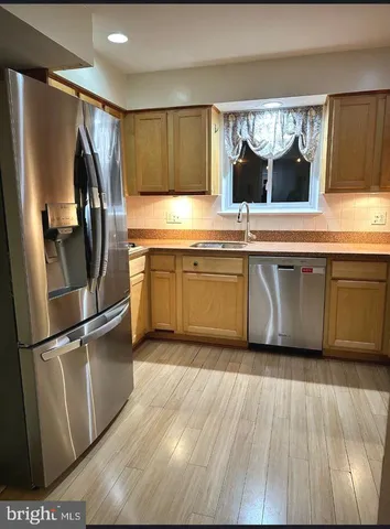 a view of an empty room with a window and a kitchen