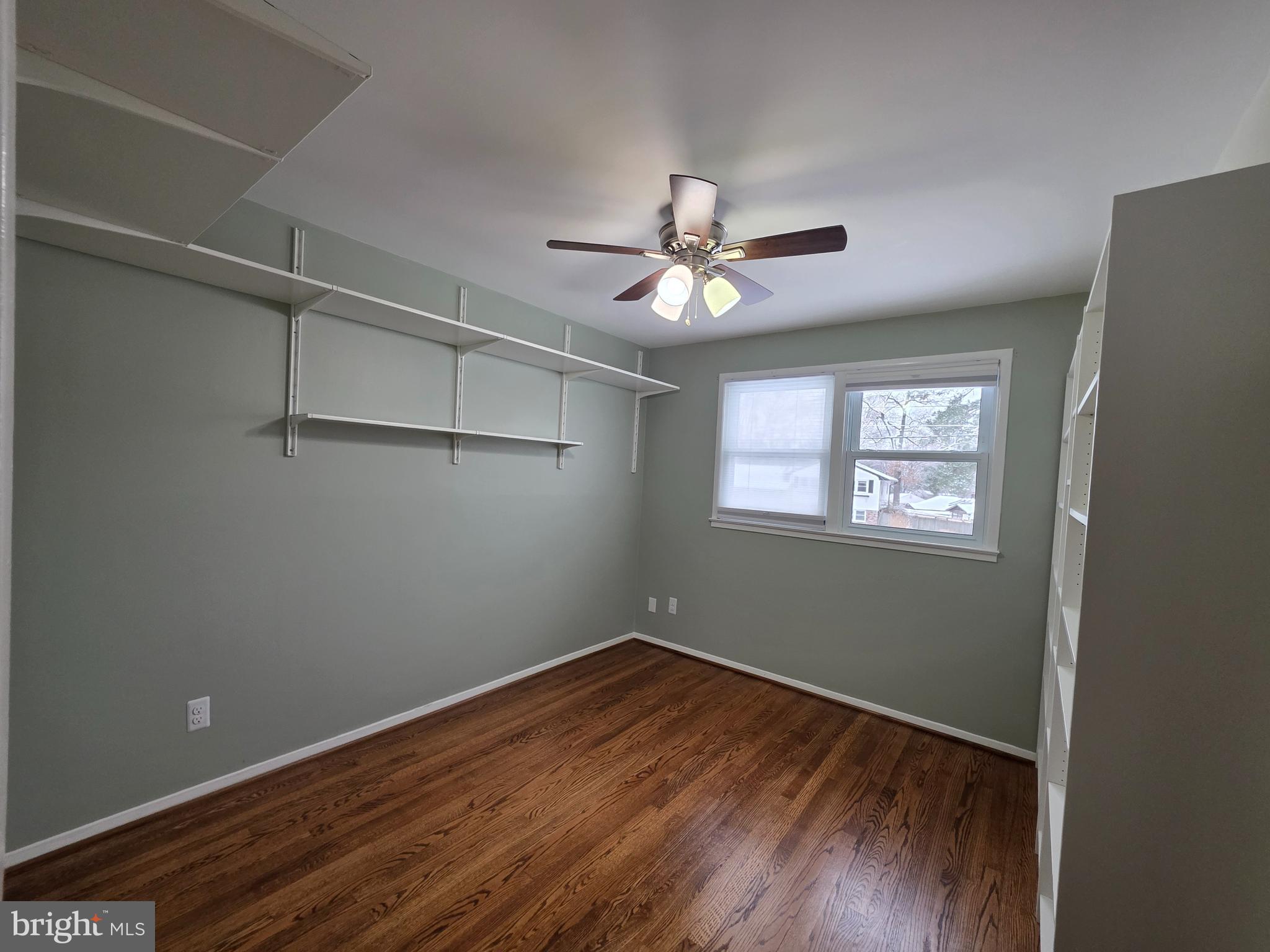 8140 Drayton Lane Springfield, VA 22151 - Photo 60 of 98 an empty room with wooden floor chandelier fan and windows