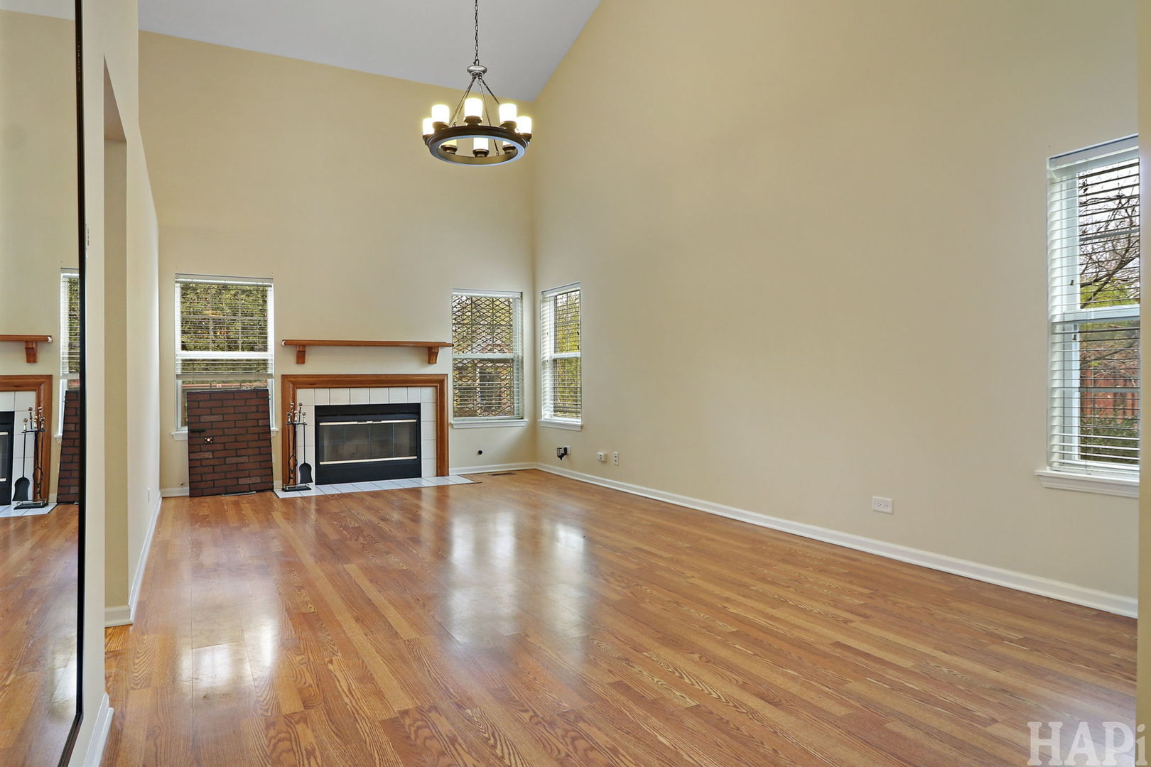 1728 Leeds Court, Unit 1728 Mundelein, IL 60060 - Photo 3 of 23 an empty room with wooden floor fireplace and windows