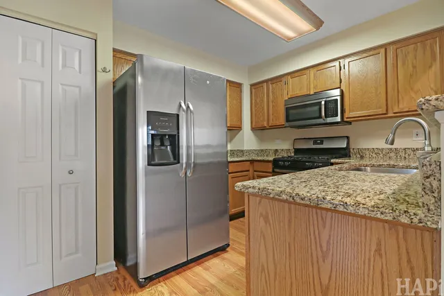 a kitchen with stainless steel appliances granite countertop a refrigerator and a stove top oven