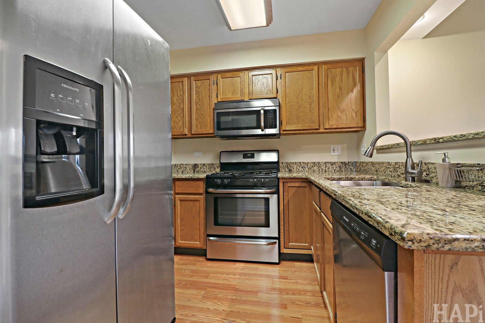 1728 Leeds Court, Unit 1728 Mundelein, IL 60060 - Photo 7 of 23 a kitchen with stainless steel appliances granite countertop a stove microwave and sink